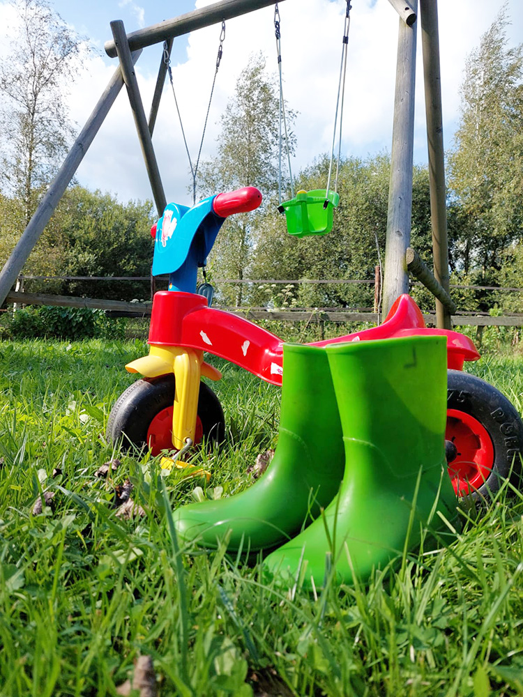 Schommel fiets en laarzen bij kinderopvang Bombay's Hoeve in Lutjegast